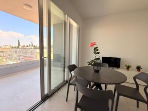 a dining room with a table and chairs and a balcony at Esmee In, Engomi in İncirli +12 photos