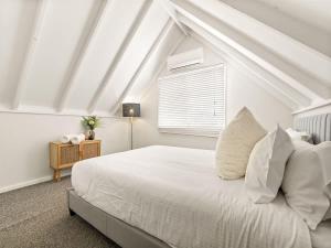 a bedroom with a white bed and a window at Pepper Cottage - Easy Beachside Living Close to Town in Dunsborough