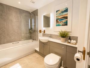 a bathroom with a toilet and a tub and a sink at Seaside Escape in Westward Ho! 3-Bed Family Holiday Home with Sea Views in Westward Ho +34 photos