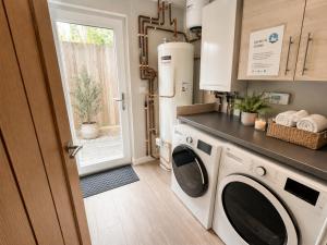 a laundry room with a washer and dryer at Seaside Escape in Westward Ho! 3-Bed Family Holiday Home with Sea Views in Westward Ho
