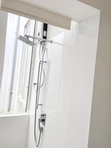 a shower in a bathroom with a window at Ayubowan Home Stay - Kotikawatta in Angoda +2 photos