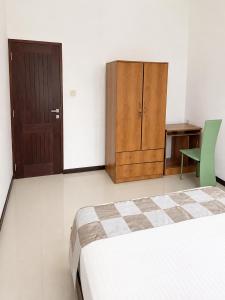 a bedroom with a bed and a desk and a cabinet at Ayubowan Home Stay - Kotikawatta in Angoda
