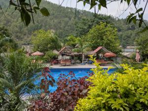 a resort swimming pool with a mountain in the background at Sukute River Hub Beach Resort in Dolālghāt +20 photos