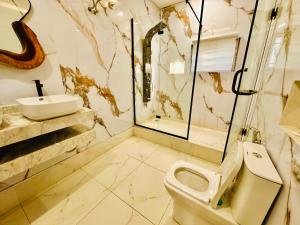 a bathroom with a toilet and a sink at Presken Hotel Castle, Opebi Lagos in Lagos +20 photos