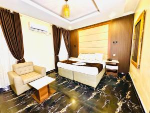 a hotel room with a bed and a chair at Presken Hotel Castle, Opebi Lagos in Lagos