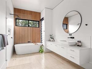 a bathroom with a tub and a sink and a mirror at Seaview Yallingup - Nature & Spa Sanctuary in Yallingup
