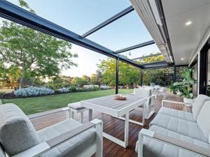 a screened in porch with a white table and chairs at Seaview Yallingup - Nature & Spa Sanctuary in Yallingup