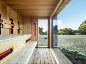 a wooden house with a large glass door at Seaview Yallingup - Nature & Spa Sanctuary in Yallingup