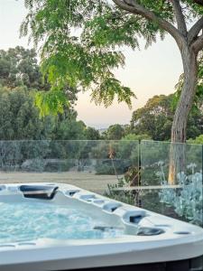 a jacuzzi tub in front of a tree at Seaview Yallingup - Nature & Spa Sanctuary in Yallingup +34 photos