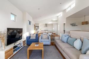 a living room with a couch and chairs and a table at Casa Bianca - Oceanview Beachside Escape in Dunsborough