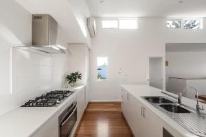 a white kitchen with a stove and a sink at Casa Bianca - Oceanview Beachside Escape in Dunsborough +27 photos