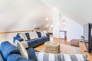 a living room with a blue couch and a tv at Banksia at Whitesands - Villa 5 Loft-Style Living by the Bay in Dunsborough