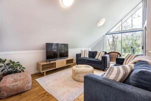 a living room with couches and a flat screen tv at Banksia at Whitesands - Villa 5 Loft-Style Living by the Bay in Dunsborough