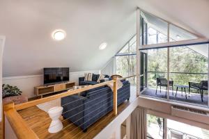 a living room with a blue couch and a large window at Banksia at Whitesands - Villa 5 Loft-Style Living by the Bay in Dunsborough +33 photos