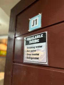 a sign on the side of a wooden door at Jace's Travellers Inn El Nido near Corong Corong Beach in El Nido