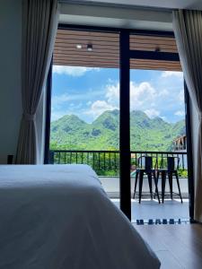 a bedroom with a bed and a view of mountains at Baram Villas Phong Nha in Hà Lời