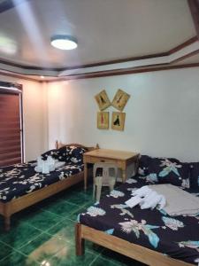 a bedroom with two beds and a table with towels at Trekkers Lodge and Cafe in Banaue