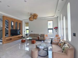 a living room with two couches and a tv at Baram Villas Phong Nha in Hà Lời