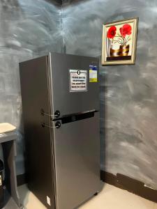 a stainless steel refrigerator with a picture on the wall at Jace's Travellers Inn El Nido near Corong Corong Beach in El Nido +45 photos