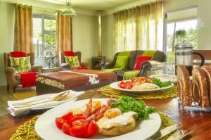 Upper House Guesthouse في كلارينس: غرفة معيشة مع طبقين من الطعام على طاولة