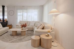 a white living room with a couch and a table at Luxury at the Cove - Seaside Comfort & Entertainment in Quindalup
