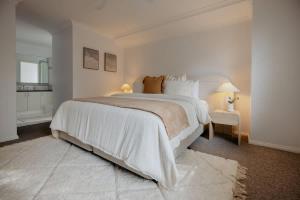a white bedroom with a large bed and a mirror at Luxury at the Cove - Seaside Comfort & Entertainment in Quindalup +36 photos