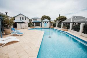 a swimming pool with two chairs and a house at Blue Haven Townhouse - Beachside Retreat with Pool Access in Gnarabup