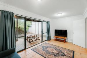a living room with a television and a table at Blue Haven Townhouse - Beachside Retreat with Pool Access in Gnarabup