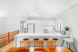 a kitchen with a white counter and three chairs at Blue Haven Townhouse - Beachside Retreat with Pool Access in Gnarabup +12 photos