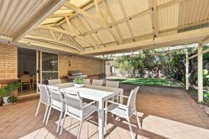 a patio with a white table and chairs at Luna Getaway in Quindalup