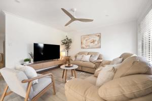 a living room with a couch and a flat screen tv at Luna Getaway in Quindalup