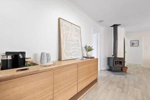 a living room with a wooden dresser and a fireplace at Luna Getaway in Quindalup