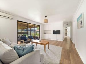 a living room with a couch and a table at Bluewater Retreat - Pet-Friendly Coastal Oasis in Broadwater