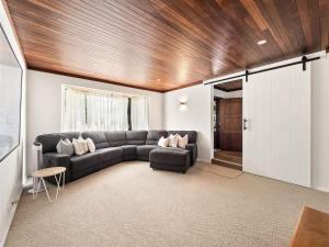 a living room with a couch and a wooden ceiling at Bluewater Retreat - Pet-Friendly Coastal Oasis in Broadwater