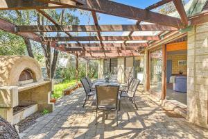 a patio with a table and chairs and an oven at Eagle Bay Beach Lodge - Escape to Coastal Serenity in Dunsborough