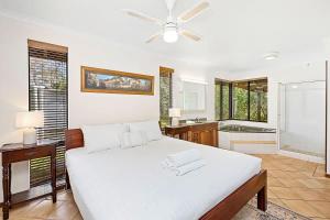 a bedroom with a large white bed and a bathroom at Eagle Bay Beach Lodge - Escape to Coastal Serenity in Dunsborough