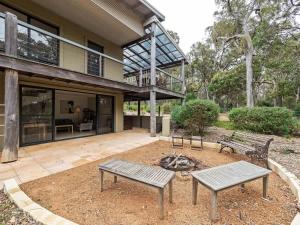a house with two benches and a fire pit at Rosella - Secluded Bushland Escape with Valley Views in Yallingup