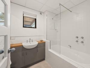 a white bathroom with a sink and a shower at Rosella - Secluded Bushland Escape with Valley Views in Yallingup +17 photos