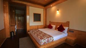 a bedroom with a large bed with red pillows at Echor Mountain Crest Jibhi in Jibhi