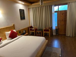 a hotel room with a large bed and a table and chairs at Echor Mountain Crest Jibhi in Jibhi +5 photos
