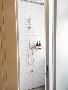 a bathroom with a shower with white subway tiles at Sukhum Ratchada Sutthisan in Bangkok