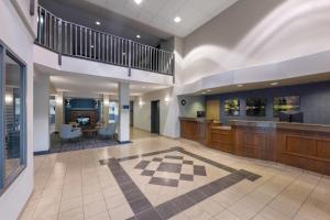 a large lobby with a staircase and a dining room at Days Inn by Wyndham Thunder Bay North in Thunder Bay