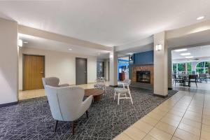 a lobby with chairs and a table and a fireplace at Days Inn by Wyndham Thunder Bay North in Thunder Bay