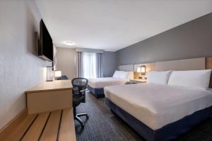 a hotel room with two beds and a desk at Days Inn by Wyndham Thunder Bay North in Thunder Bay +66 photos