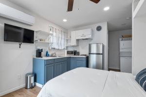 a small kitchen with blue cabinets and a refrigerator at Le Petite Willow - Guesthouse in Modesto