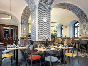 a restaurant with tables and chairs in a room at Mercure Vienna First in Vienna