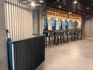 eine Bar mit Stühlen und Tischen in einem Raum in der Unterkunft Little Loft Hotel in Phuket