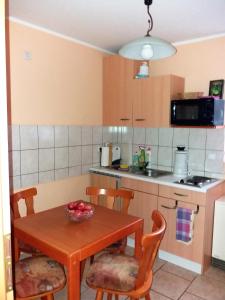 uma pequena cozinha com uma mesa de madeira e cadeiras em Hexenhaus am Waldesrand Wernigerode em Wernigerode