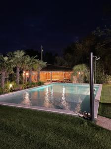 a swimming pool in a yard at night at Villa Palma Balatonboglár in Balatonboglár