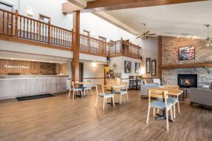 a lobby with tables and chairs and a fireplace at AmericInn by Wyndham Hutchinson in Hutchinson